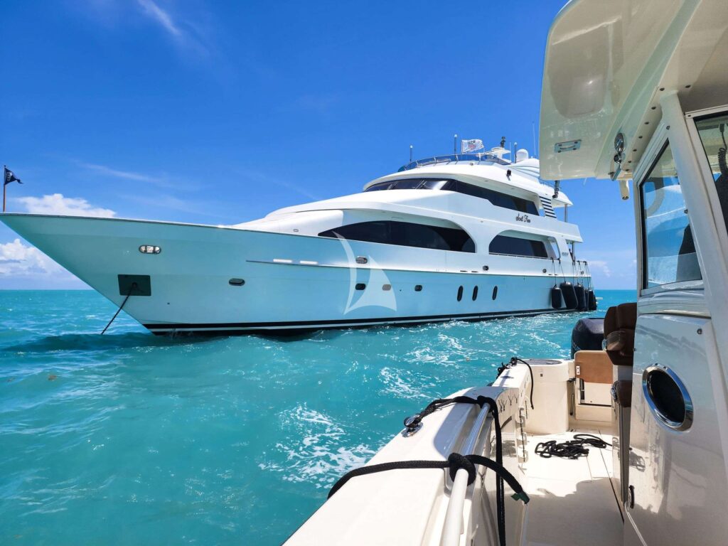 Graceful 7506 luxury yacht on tranquil waters near coastline.