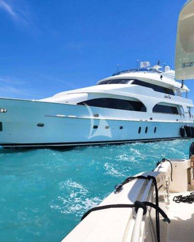 Graceful 7506 luxury yacht on tranquil waters near coastline.